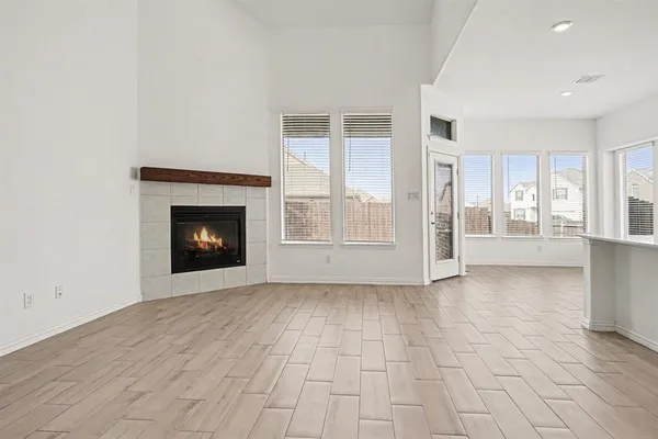a view of an empty room with a fireplace and a window