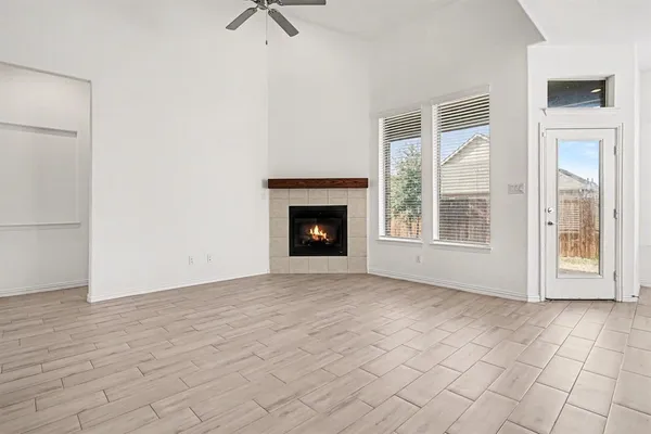 a view of an empty room with window and fire place