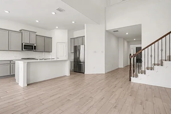 a view of kitchen with stainless steel appliances refrigerator microwave and stove
