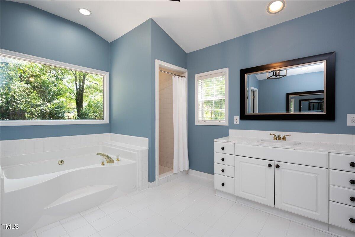 2803 Exeter Circle Raleigh, NC 27608 - Photo 21 of 38 a bathroom with a bathtub sink and mirror