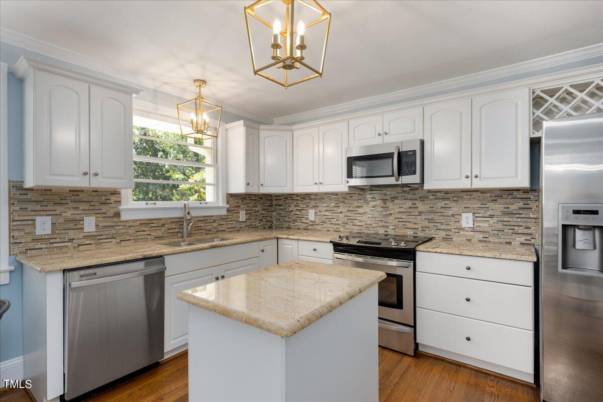 2803 Exeter Circle Raleigh, NC 27608 - Photo 9 of 38 a kitchen with white cabinets appliances and a window