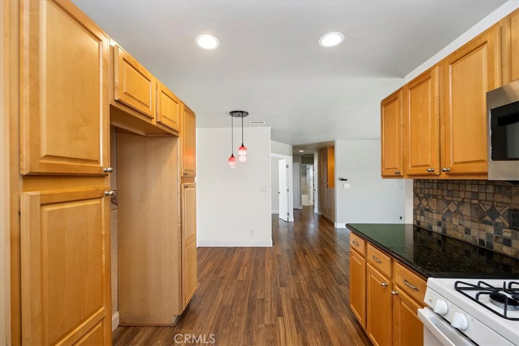 3112 Glenn Road Oceanside, CA 92056 - Photo 13 of 30 a kitchen with granite countertop wooden floors and stainless steel appliances