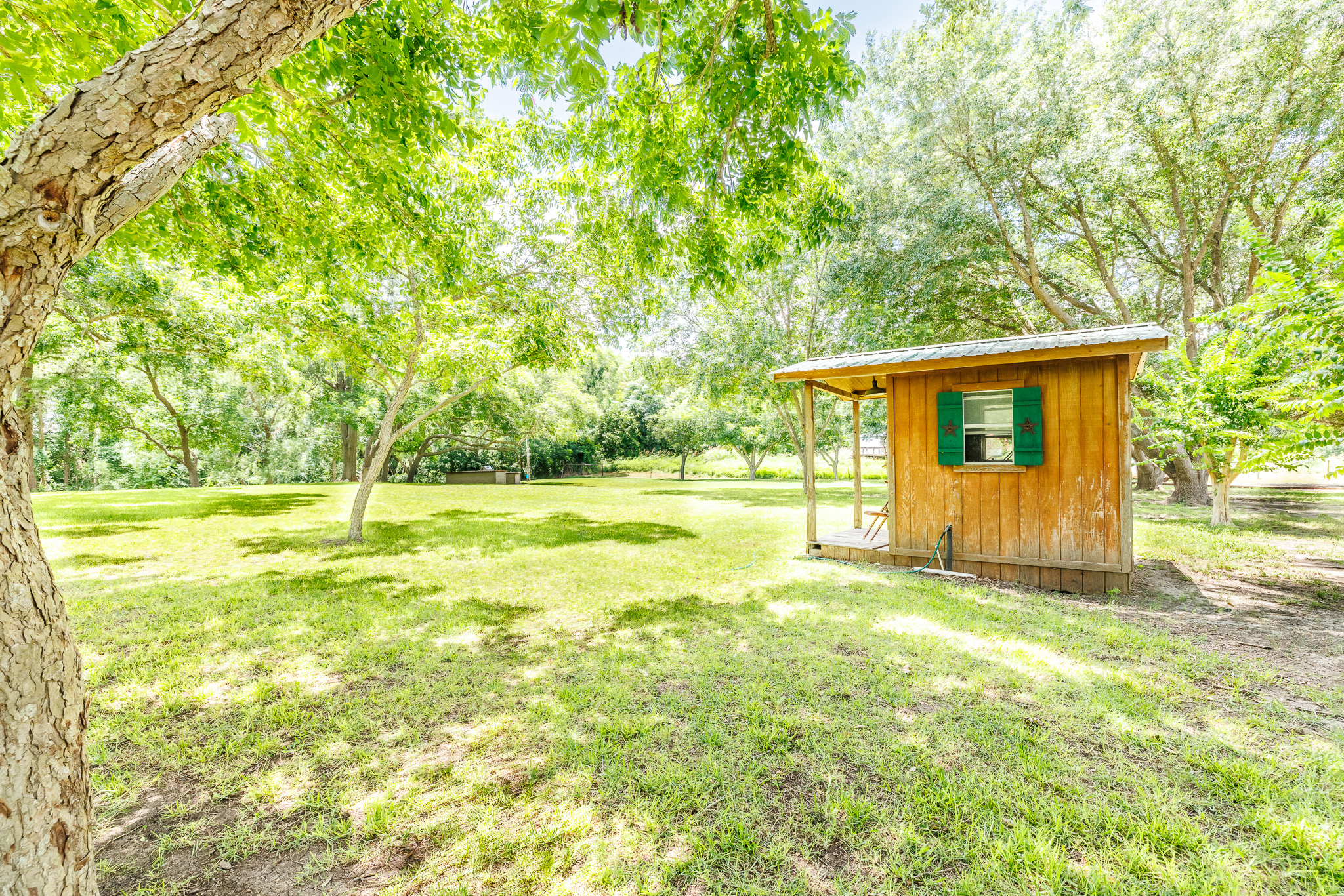 Tbd Goodwin Road Gonzales, TX 78629 - Photo 12 of 33 A charming wooden shed nestled amidst a verdant landscape, perfect for a private retreat.