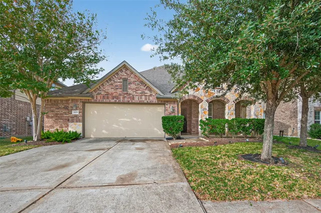 front view of a house with a yard and an trees