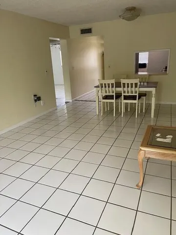 a dining room with furniture and a view of kitchen