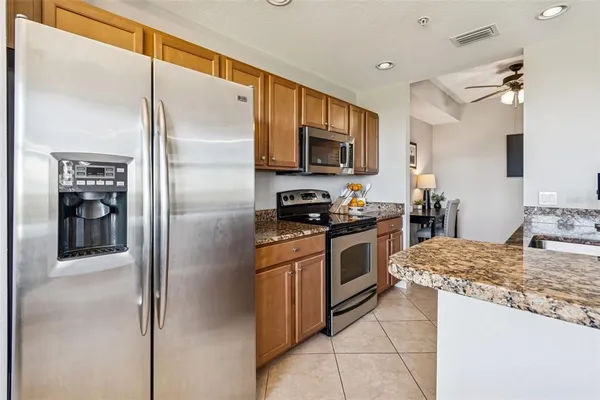 a kitchen with stainless steel appliances granite countertop a sink stove and refrigerator