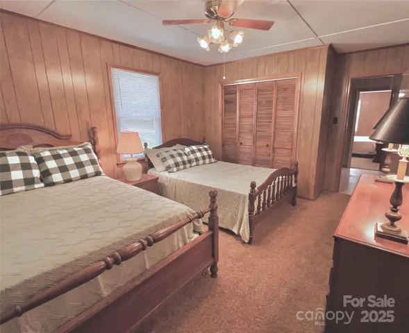 an aerial view of a house with swimming pool and large trees