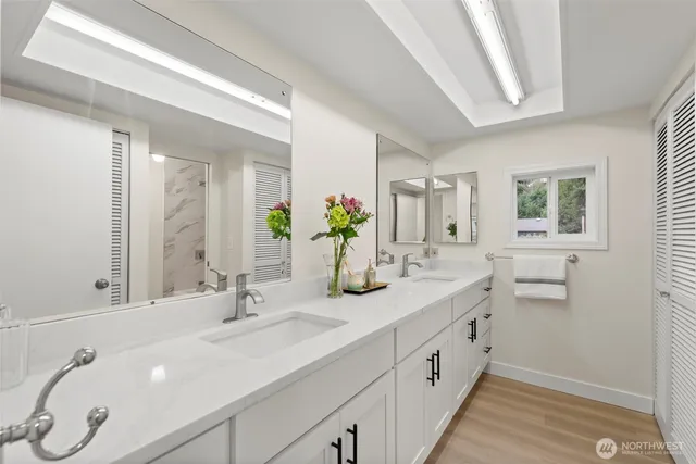 a bathroom with double vanity and a mirror