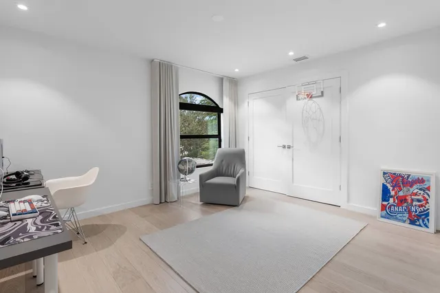 a living room with furniture a large window and potted plants
