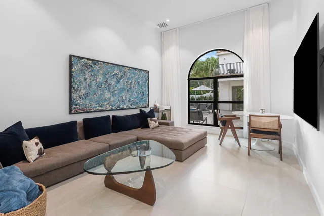 a view of swimming pool with lawn chairs and plants