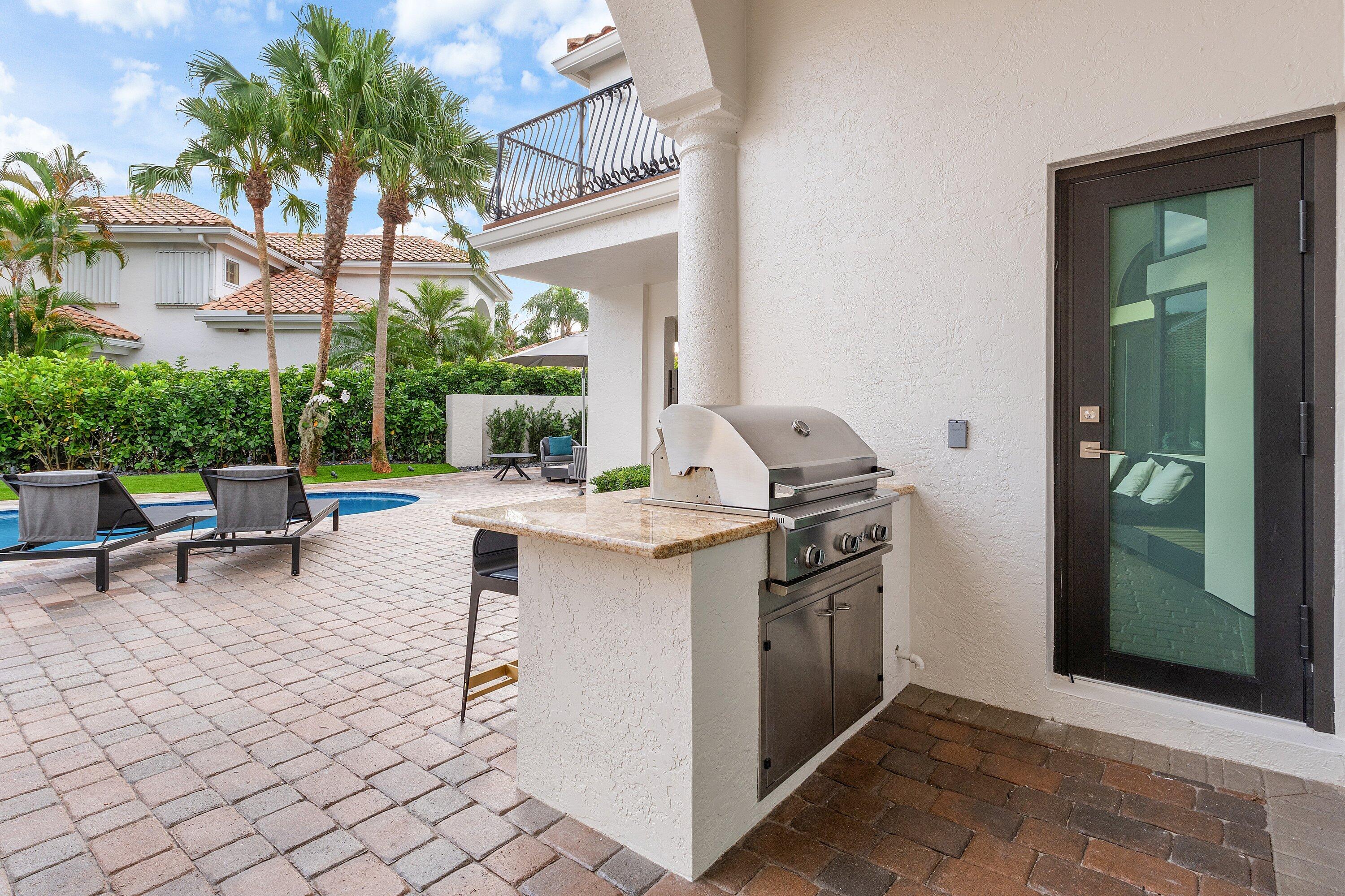 6026 Northwest 31st Way Boca Raton, FL 33496 - Photo 42 of 61 a kitchen with granite countertop a sink and a stove