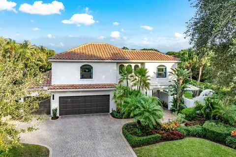 an aerial view of residential houses with outdoor space and trees all around