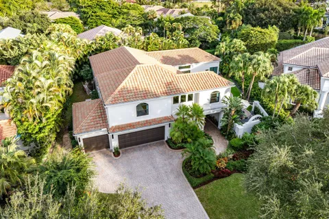 an aerial view of residential house with outdoor space and trees all around