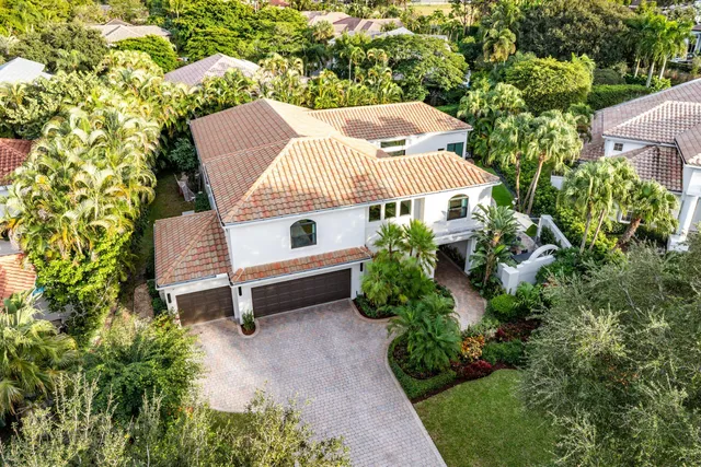 an aerial view of residential house with outdoor space and trees all around