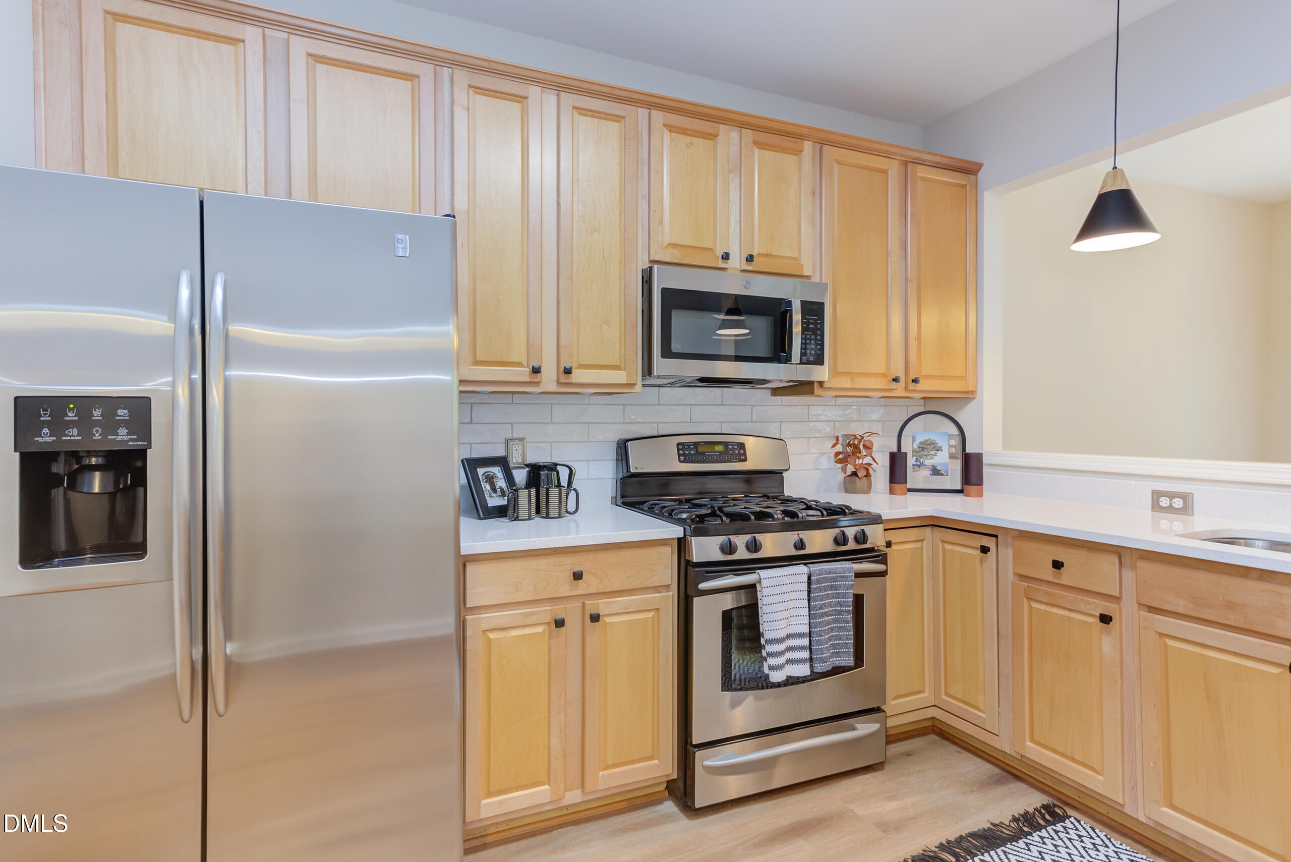 5620 Berry Creek Circle Raleigh, NC 27613 - Photo 14 of 38 a kitchen with white cabinets and stainless steel appliances