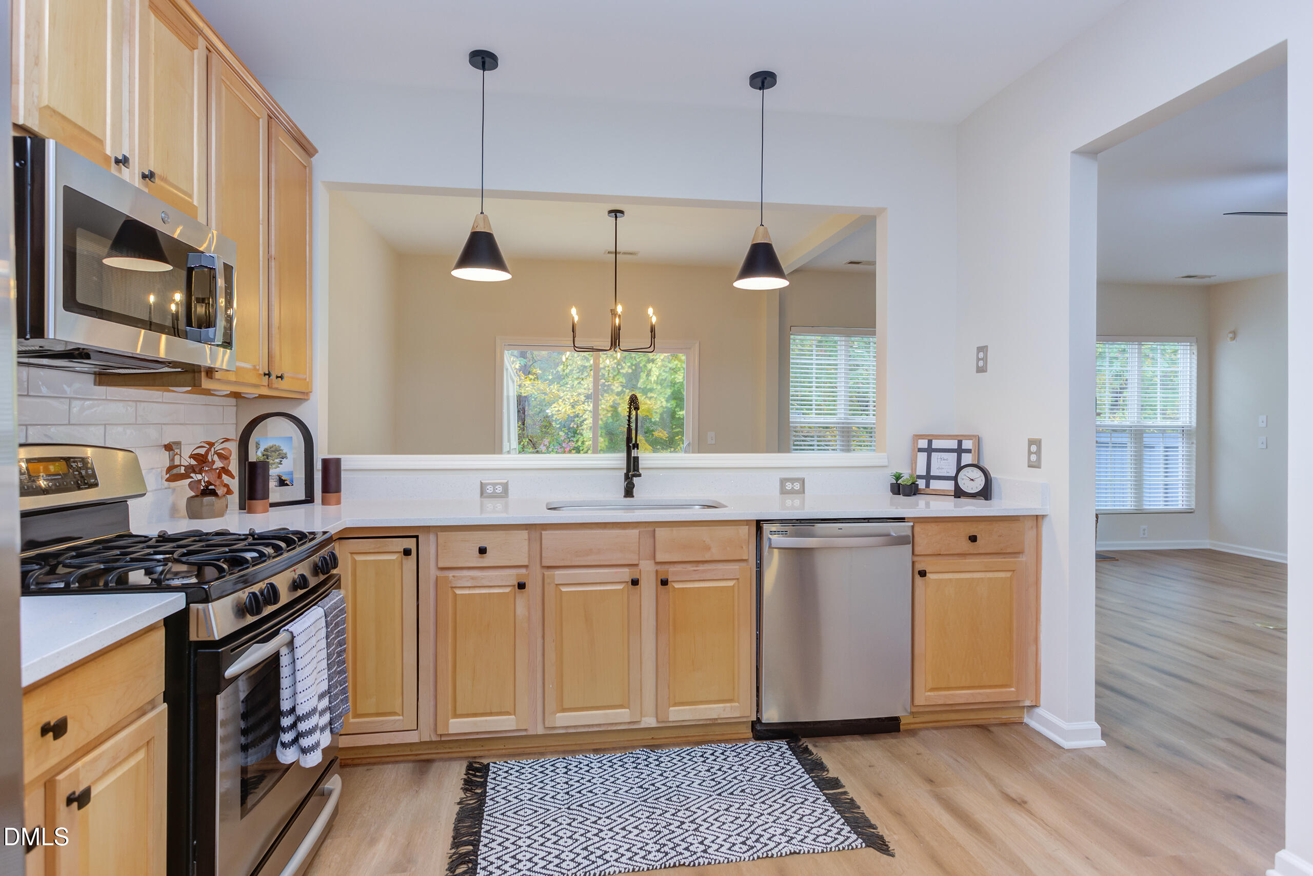 5620 Berry Creek Circle Raleigh, NC 27613 - Photo 15 of 38 a kitchen with stainless steel appliances granite countertop a stove a sink and a wooden floor