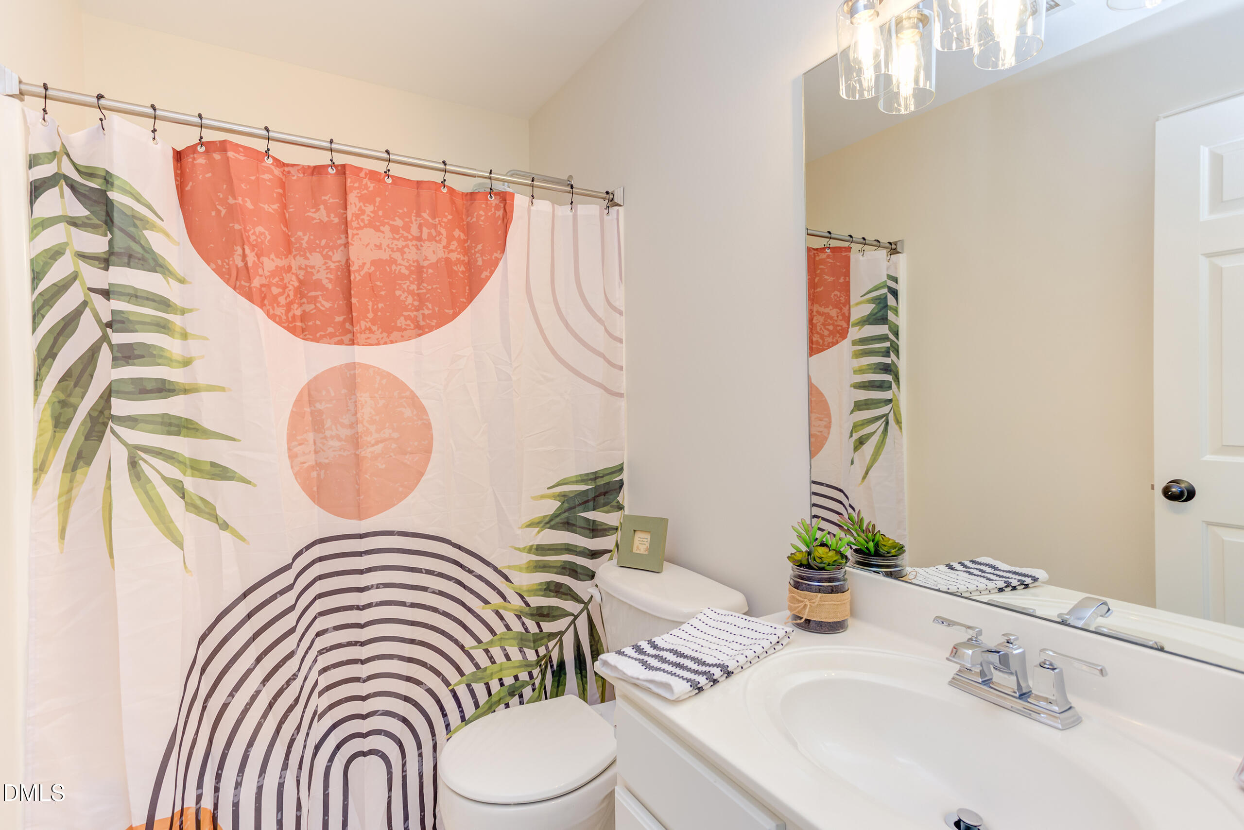 5620 Berry Creek Circle Raleigh, NC 27613 - Photo 29 of 38 a bathroom with a sink a mirror and a shower curtain