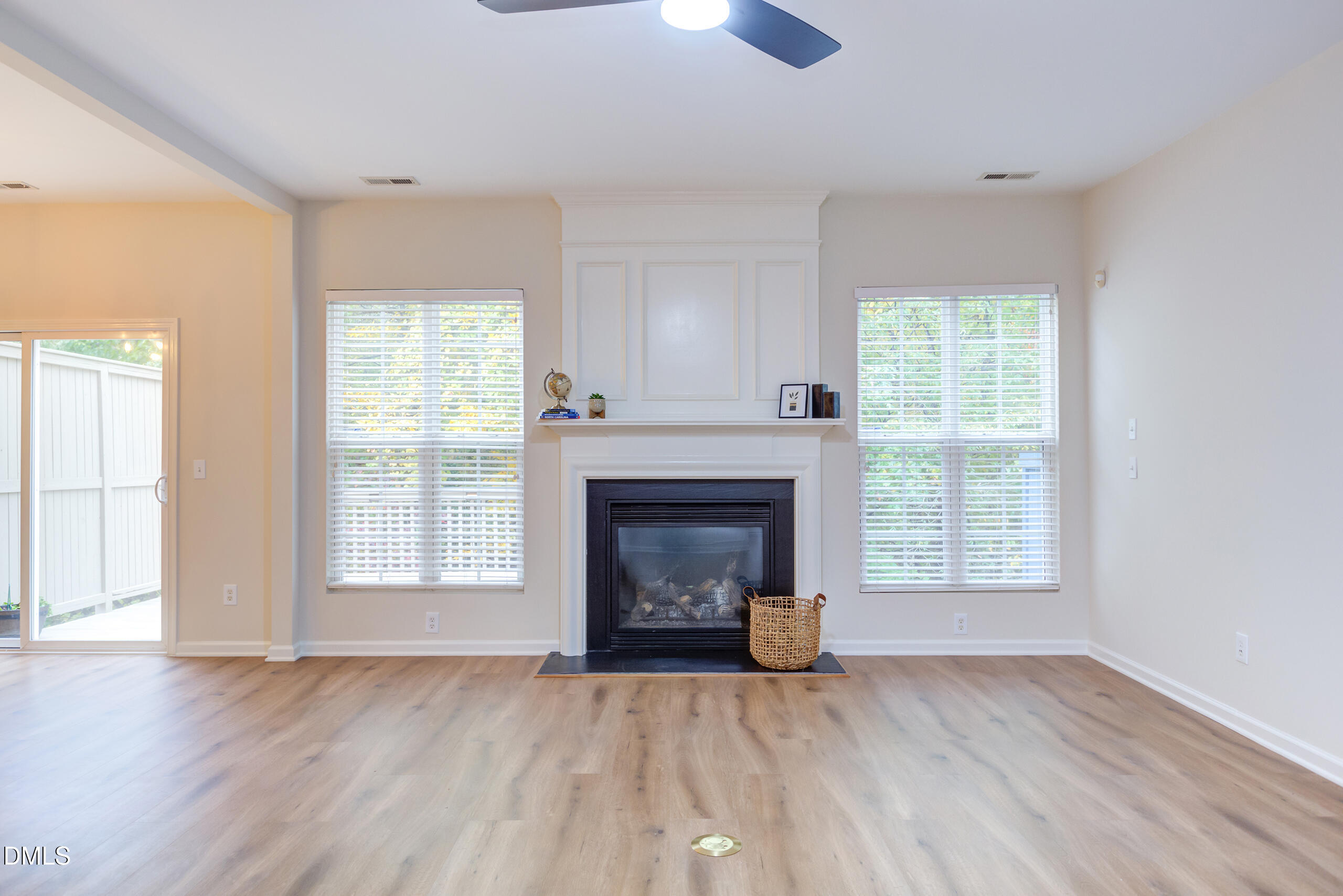 5620 Berry Creek Circle Raleigh, NC 27613 - Photo 5 of 38 an empty room with wooden floor fireplace and windows