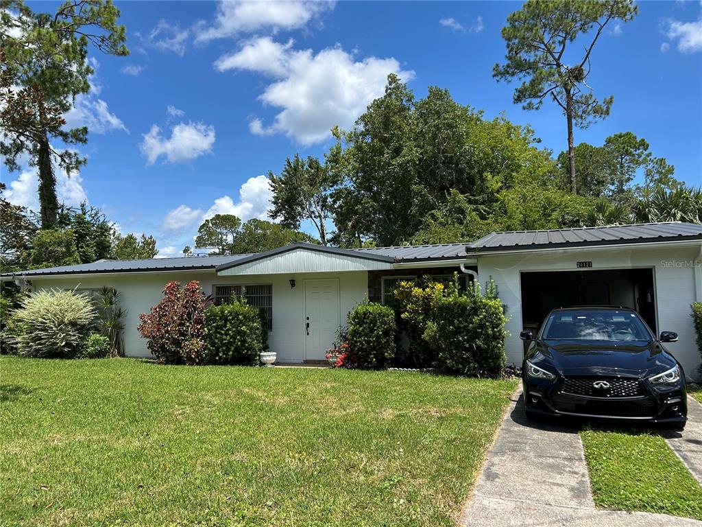 24121 Armadillo Road Astor, FL 32102 - Photo 2 of 11 a front view of a house with garden