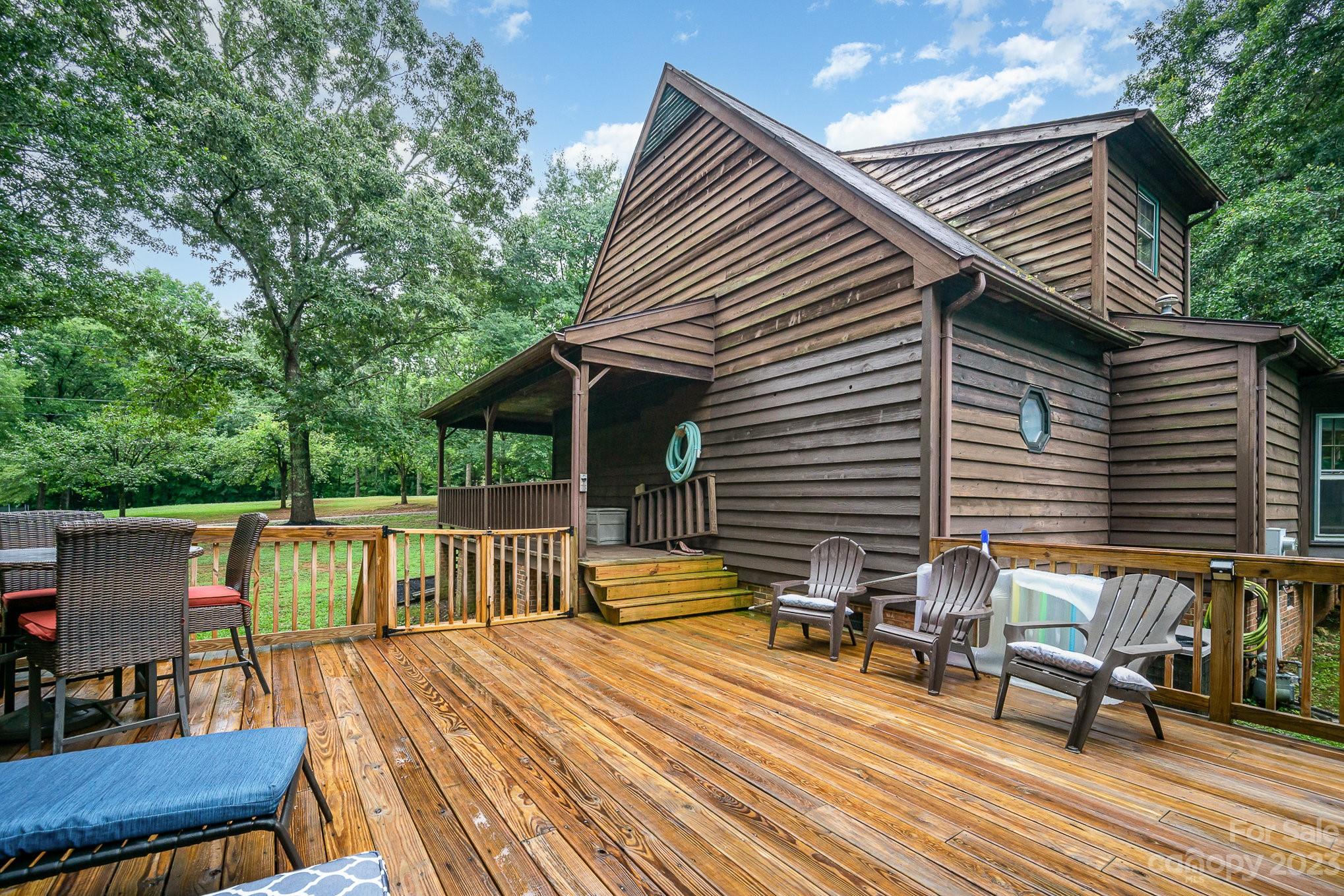 427 Laurel Hills Road Indian Land, SC 29707 - Photo 25 of 32 a view of a roof deck with table and chairs couches with wooden floor and fence