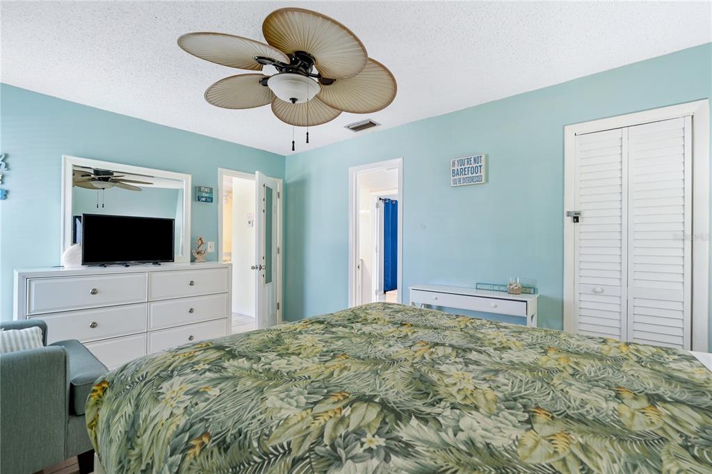 230 Medallion Boulevard, Unit E Madeira Beach, FL 33708 - Photo 13 of 35 a bedroom with a bed and a flat screen tv