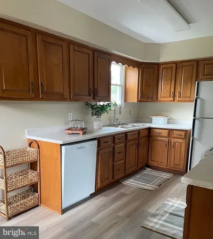 a kitchen with stainless steel appliances granite countertop a sink a stove cabinets and wooden floor