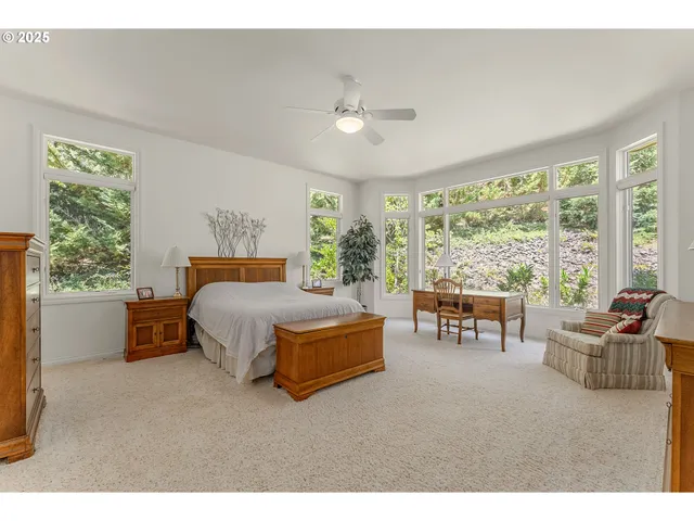 a bedroom with furniture and a large window