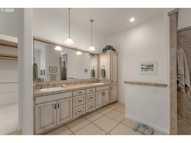 a bathroom with a granite countertop sink a toilet a mirror and shower