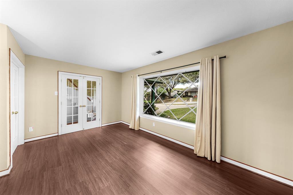 207 Summit Ridge Drive Rockwall, TX 75087 - Photo 15 of 28 a view of an empty room with wooden floor and a window