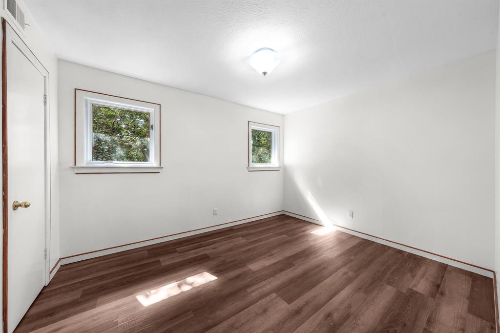207 Summit Ridge Drive Rockwall, TX 75087 - Photo 22 of 28 an empty room with wooden floor and windows
