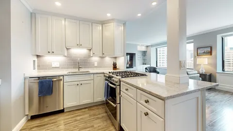a kitchen with granite countertop white cabinets and white appliances