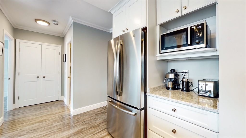 65 East India Row, Unit 24H Boston, MA 02110 - Photo 18 of 27 a kitchen with stainless steel appliances granite countertop a refrigerator and microwave