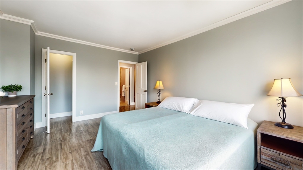 65 East India Row, Unit 24H Boston, MA 02110 - Photo 21 of 27 a bedroom with a bed and a lamp