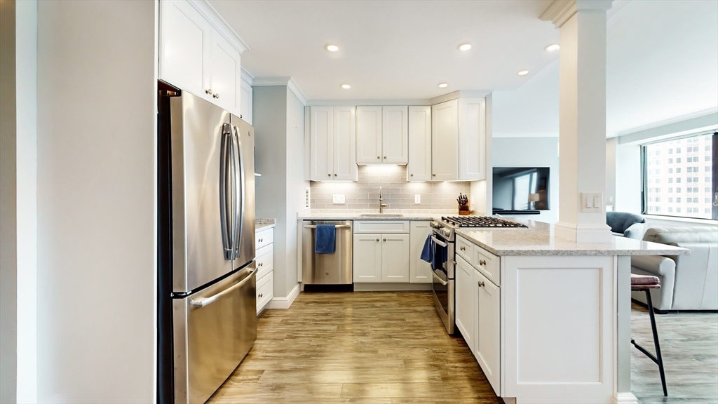 65 East India Row, Unit 24H Boston, MA 02110 - Photo 3 of 27 a kitchen with white cabinets and stainless steel appliances