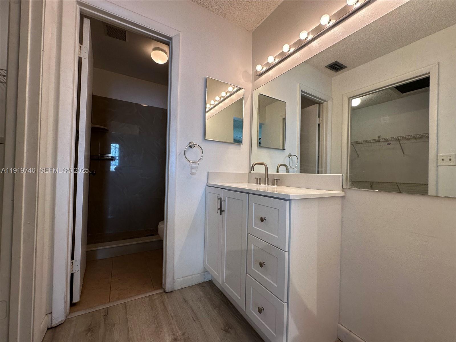 1024 South Independence Drive, Unit 1024A Homestead, FL 33034 - Photo 11 of 26 a bathroom with a double vanity sink a mirror and a shower