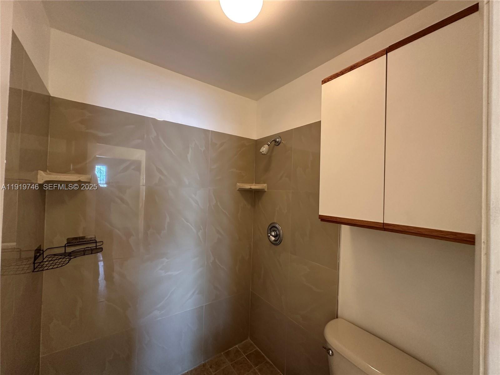 1024 South Independence Drive, Unit 1024A Homestead, FL 33034 - Photo 13 of 26 a bathroom with a shower and toilet