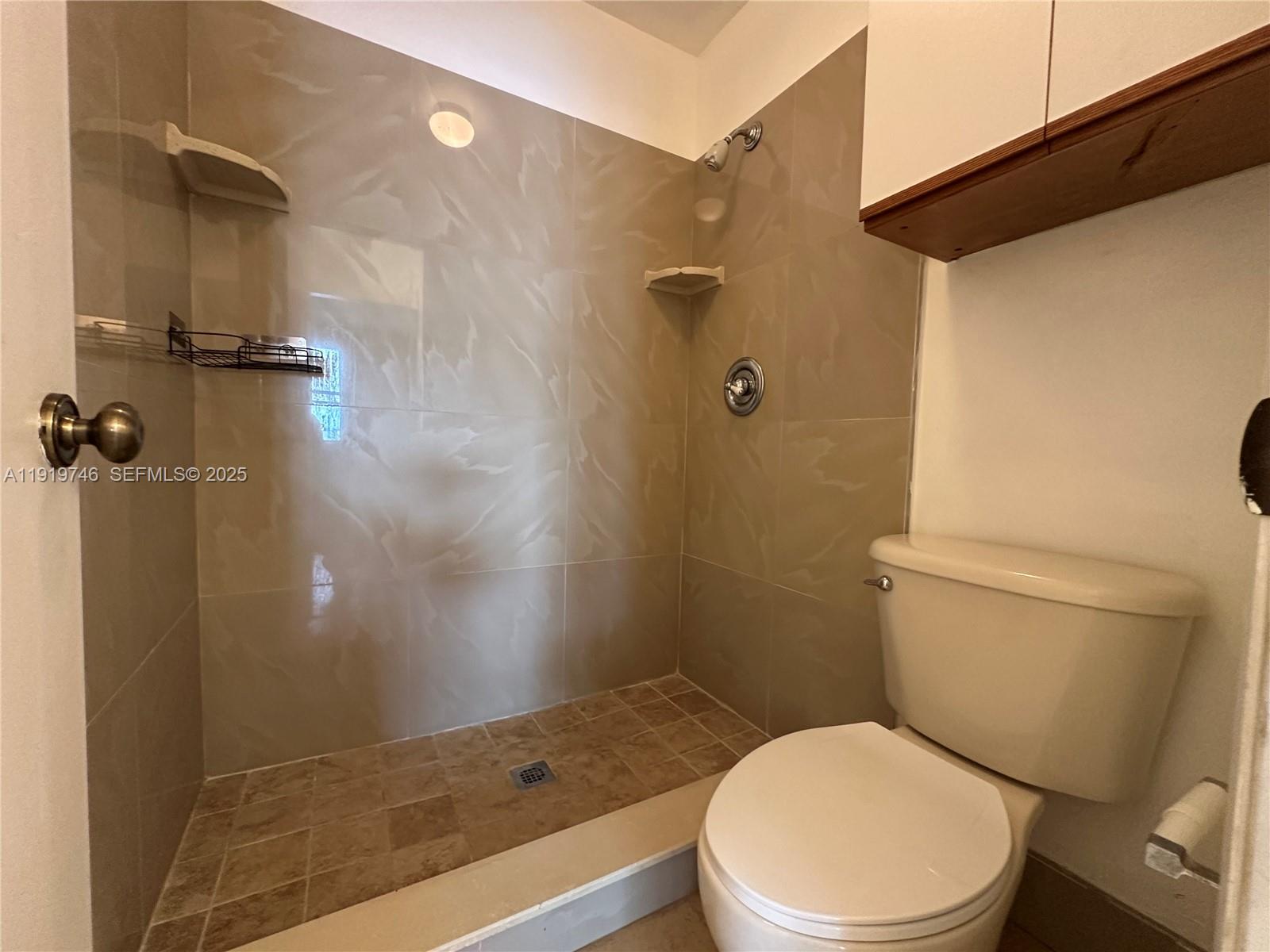 1024 South Independence Drive, Unit 1024A Homestead, FL 33034 - Photo 15 of 26 a white toilet sitting next to a bathroom sink and a shower