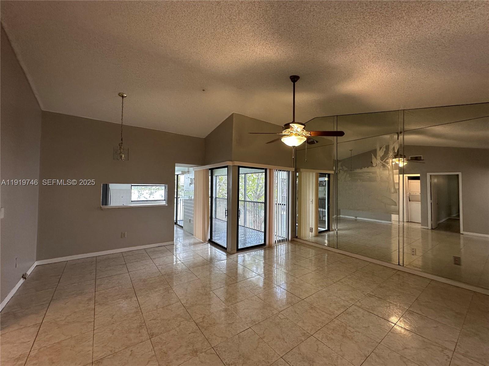 1024 South Independence Drive, Unit 1024A Homestead, FL 33034 - Photo 2 of 26 a view of an empty room with window and chandelier fan