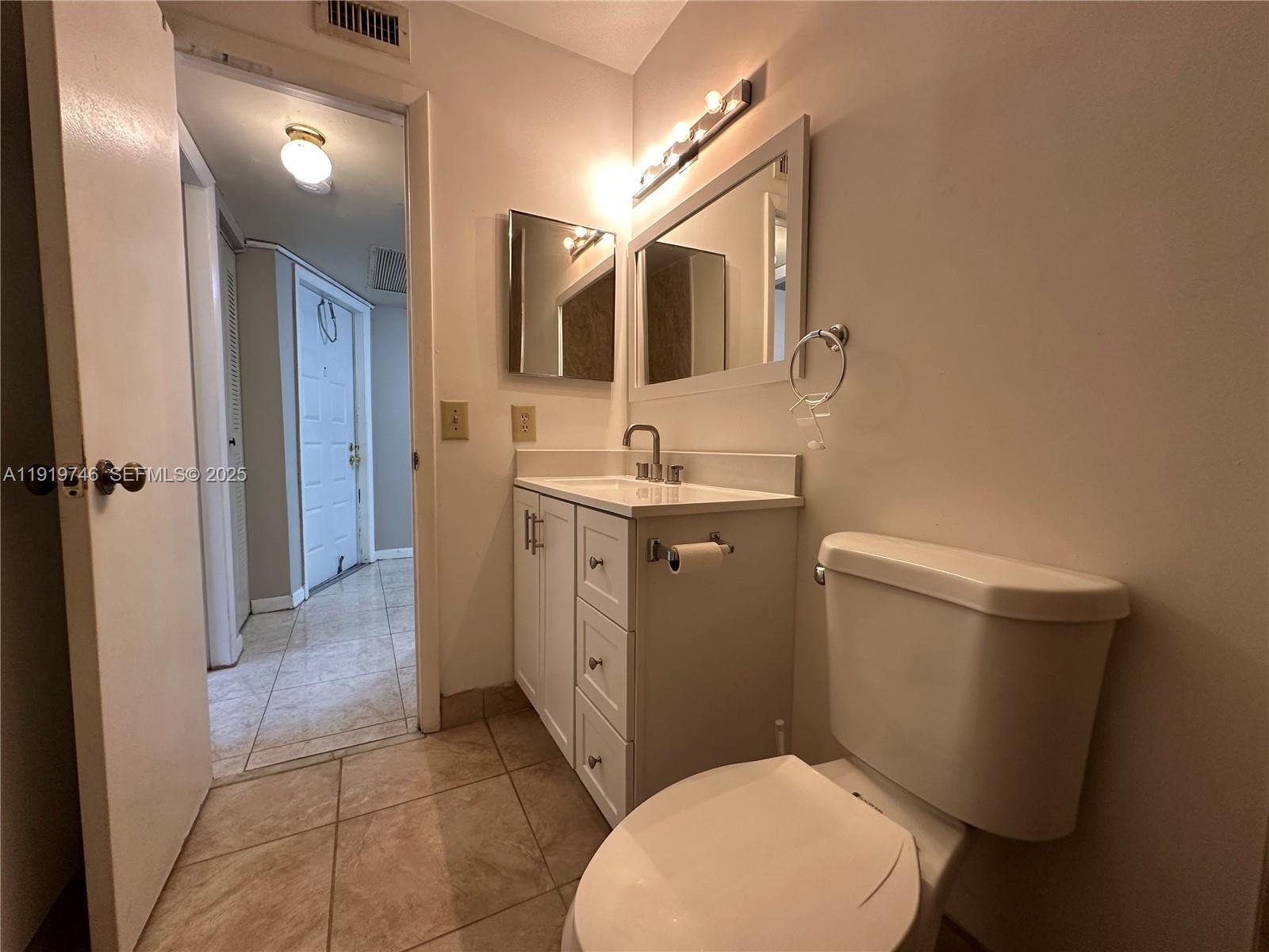 1024 South Independence Drive, Unit 1024A Homestead, FL 33034 - Photo 24 of 26 a bathroom with a toilet sink and mirror