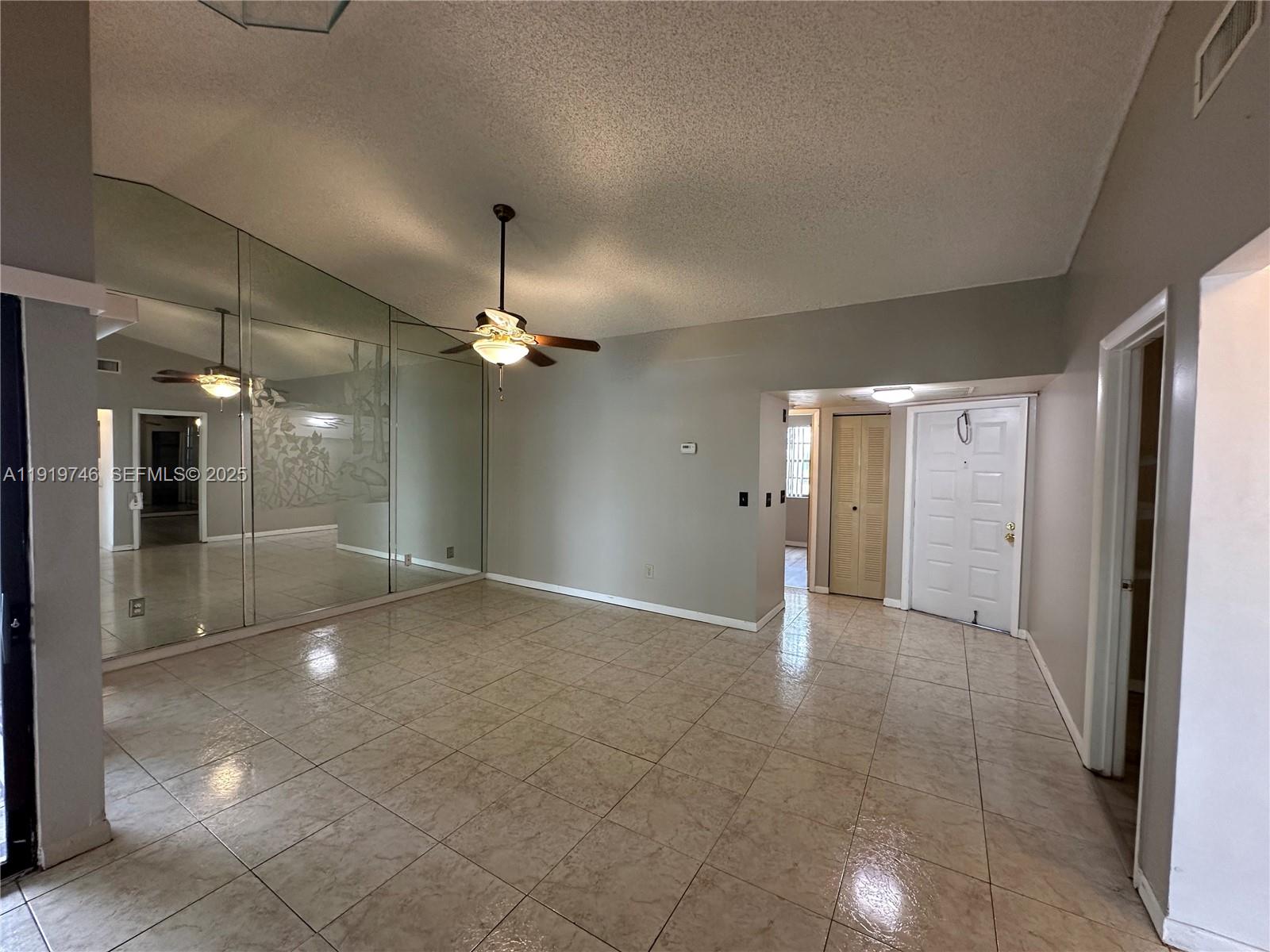 1024 South Independence Drive, Unit 1024A Homestead, FL 33034 - Photo 4 of 26 a view of a big room with windows and chandelier fan