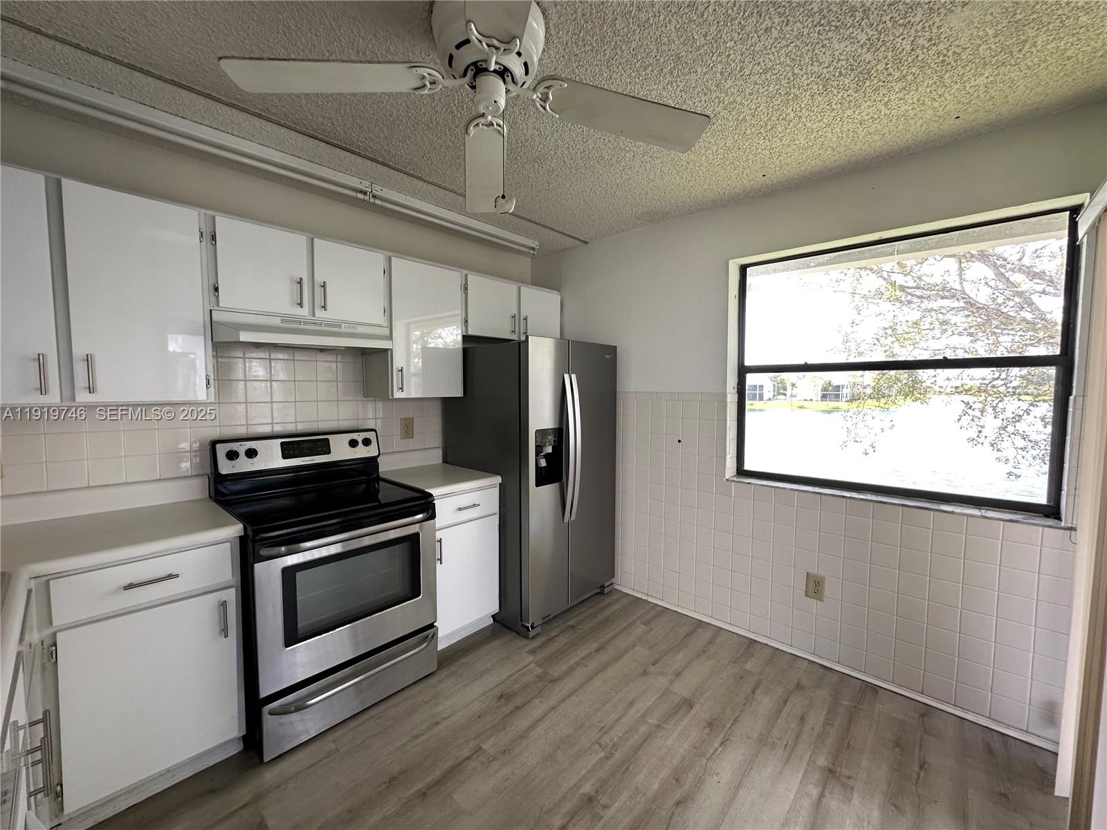 1024 South Independence Drive, Unit 1024A Homestead, FL 33034 - Photo 7 of 26 a kitchen with stainless steel appliances a stove a refrigerator and a window