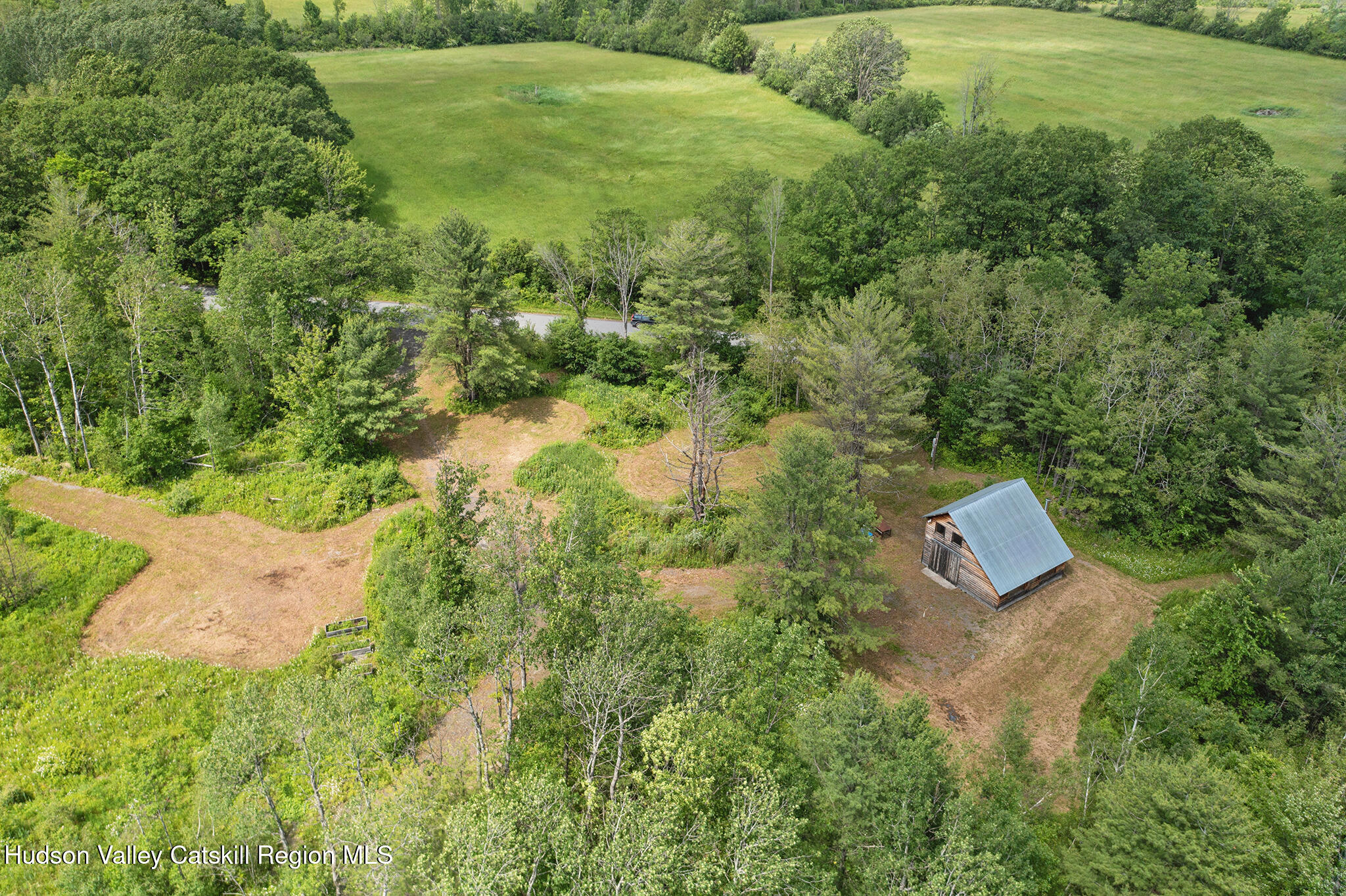 an aerial view of residential house with outdoor space and trees all around