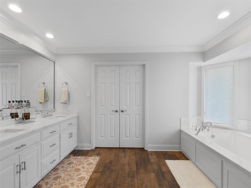 1103 Marigold Lane Longview, TX 75604 - Photo 22 of 34 a bathroom with a double vanity sink a mirror and a bathtub