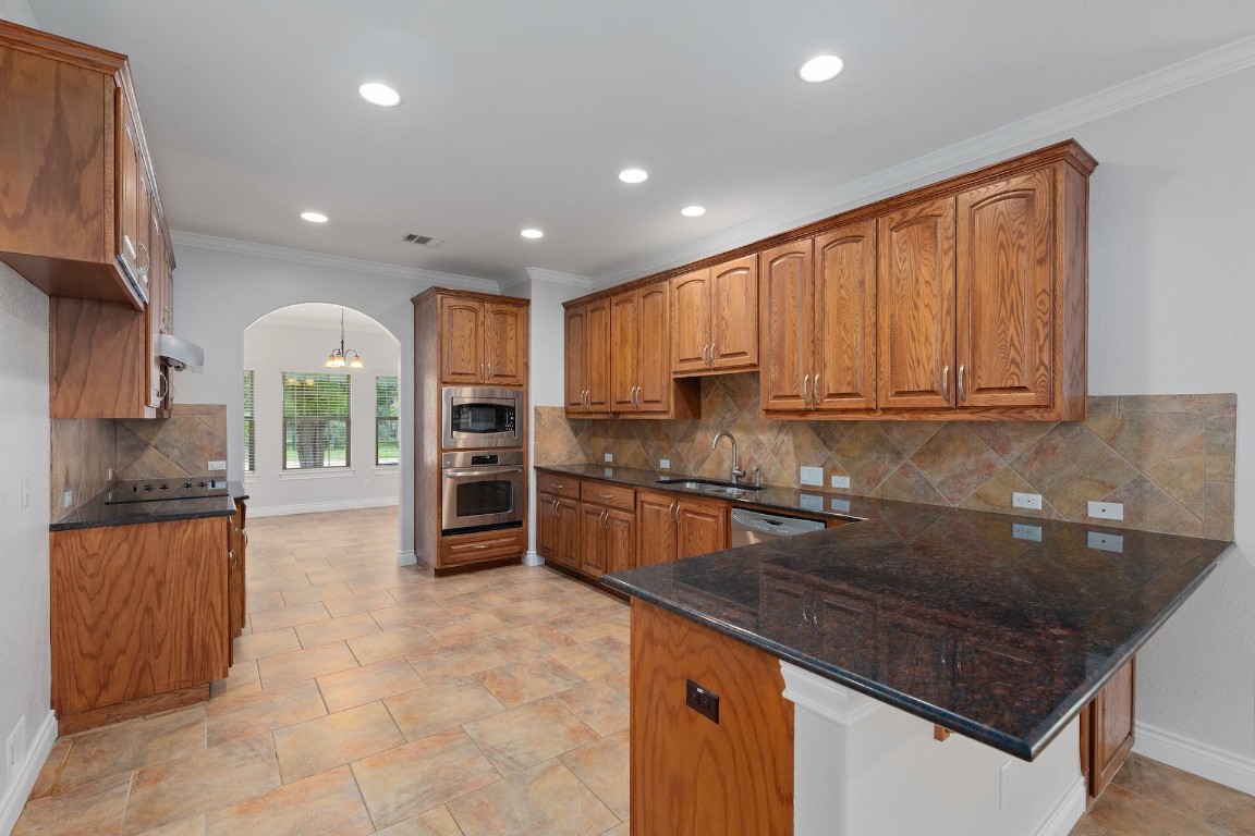 1001 Fort Davis Street Georgetown, TX 78633 - Photo 19 of 40 a kitchen with stainless steel appliances granite countertop a stove a sink and a refrigerator
