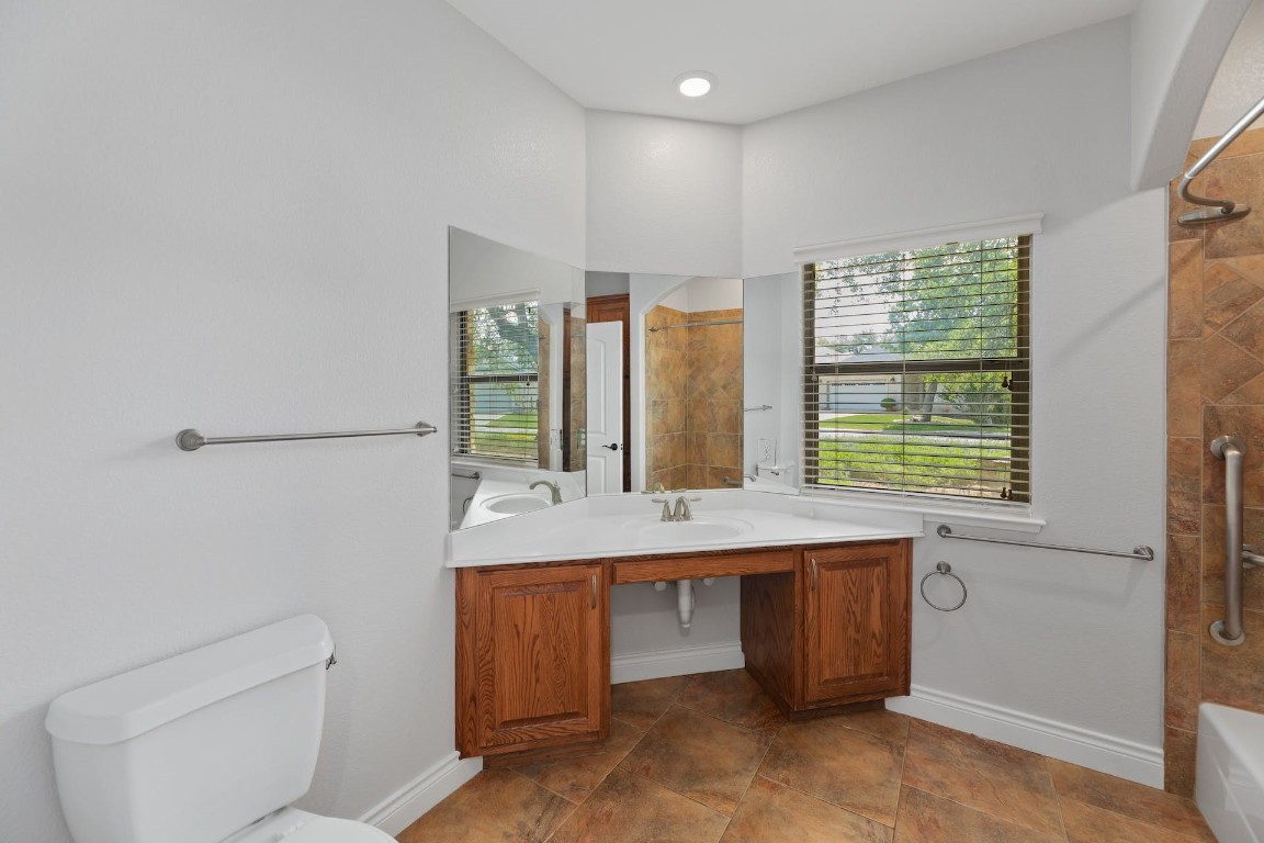 1001 Fort Davis Street Georgetown, TX 78633 - Photo 32 of 40 a bathroom with a granite countertop sink a toilet and mirror