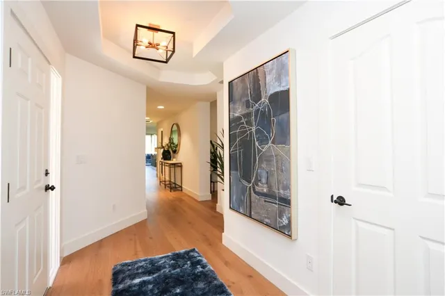 a view of a hallway with wooden floor and a living room