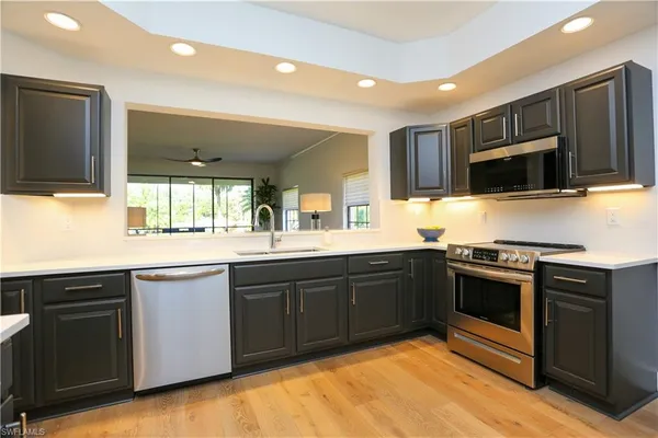 a kitchen with stainless steel appliances granite countertop a stove top oven microwave and sink