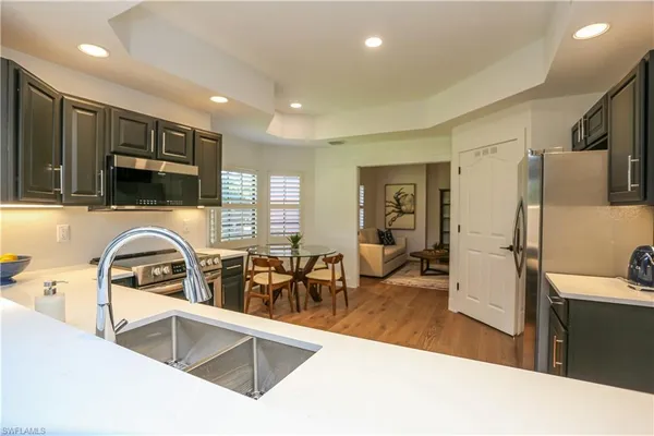 a kitchen with stainless steel appliances granite countertop a sink and a refrigerator