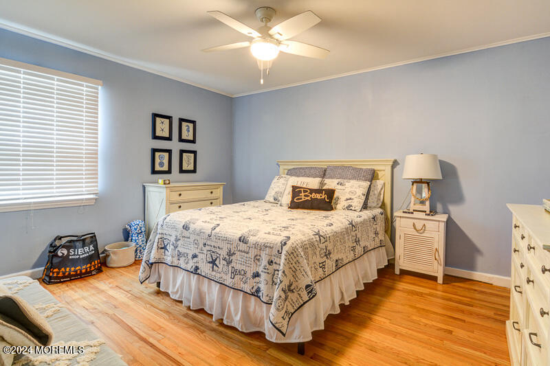 419 Jersey Avenue Spring Lake, NJ 07762 - Photo 14 of 32 a bedroom with a bed and a chandelier