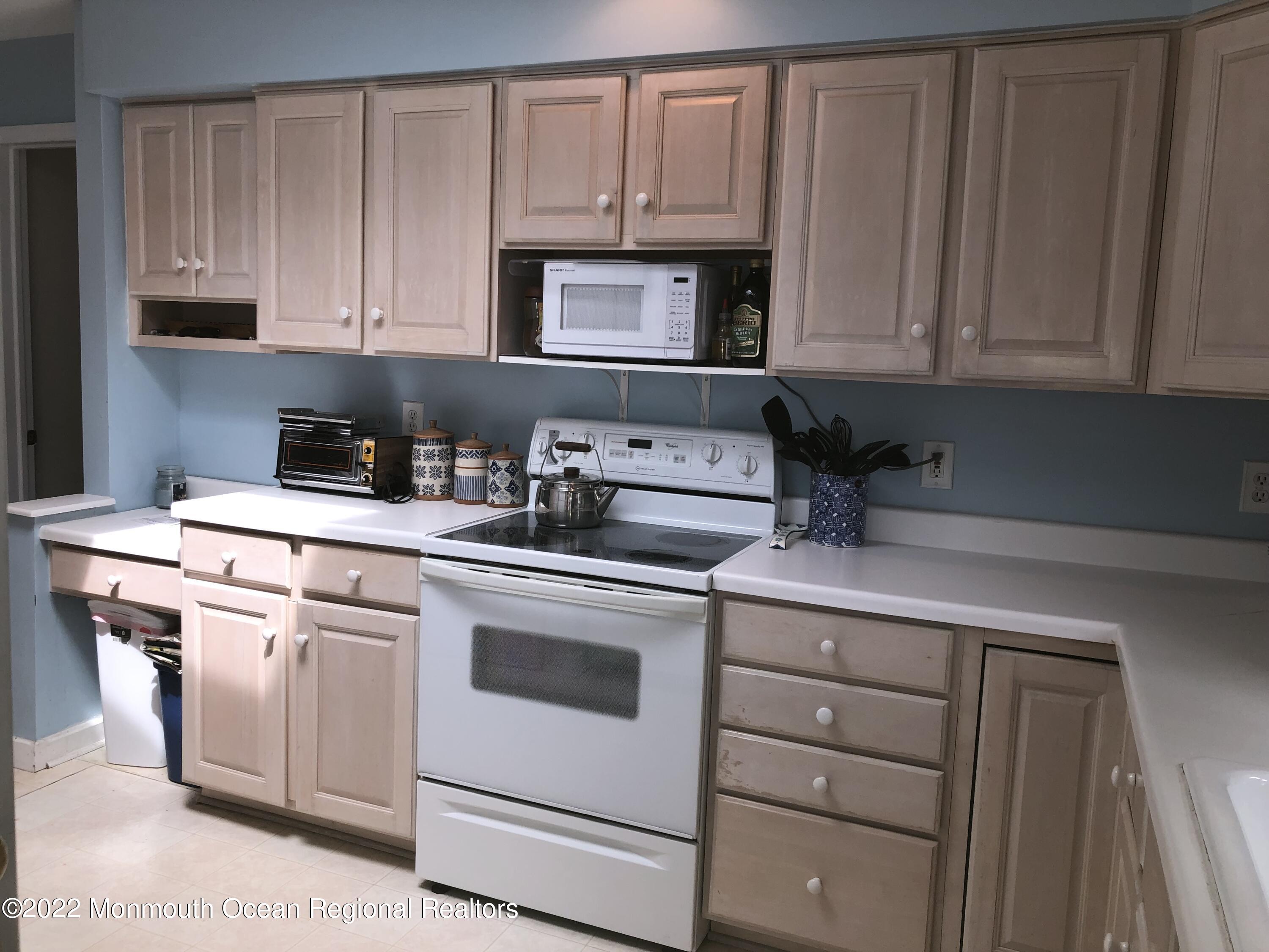 419 Jersey Avenue Spring Lake, NJ 07762 - Photo 32 of 32 a kitchen with granite countertop white cabinets and white appliances